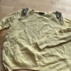 Yellow knit sweater with shoulder embellishments
